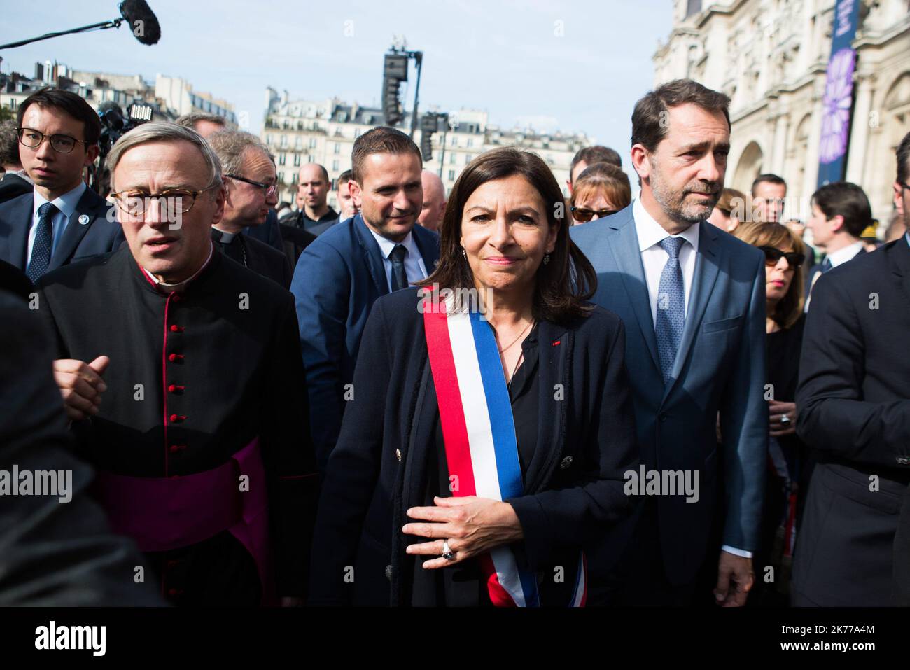 Jean-Marc Chauve, French Interior Minister Christophe Castaner, Paris prefect Didier Lallement, Paris mayor Anne Hidalgo, and other officials walk by Notre Dame cathedral on April 18, 2019 in Paris. France paid a daylong tribute on April 18, 2019 to the Paris firefighters who saved Notre Dame Cathedral from collapse, while construction workers rushed to secure an area above one of the church's famed rose-shaped windows and other vulnerable sections of the fire-damaged landmark.   Stock Photo
