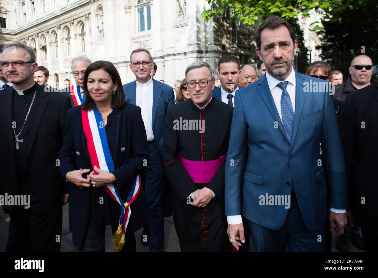 Jean-Marc Chauve, French Interior Minister Christophe Castaner, Paris prefect Didier Lallement, Paris mayor Anne Hidalgo, and other officials walk by Notre Dame cathedral on April 18, 2019 in Paris. France paid a daylong tribute on April 18, 2019 to the Paris firefighters who saved Notre Dame Cathedral from collapse, while construction workers rushed to secure an area above one of the church's famed rose-shaped windows and other vulnerable sections of the fire-damaged landmark  Stock Photo