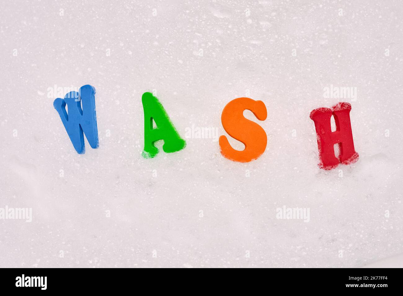 Relevant words spelled out with foam letters in soap bubbles in the