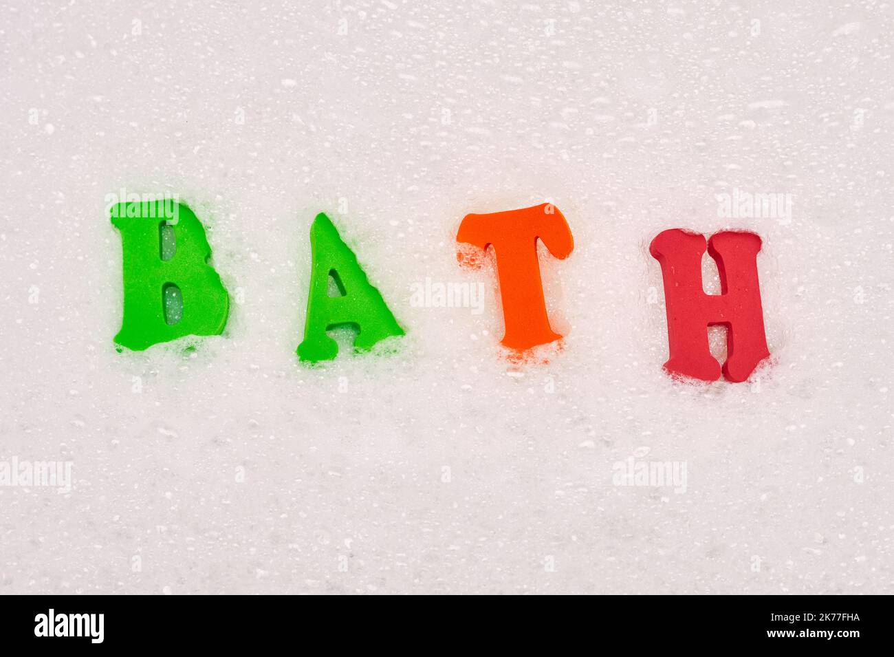 Relevant words spelled out with foam letters in soap bubbles in the