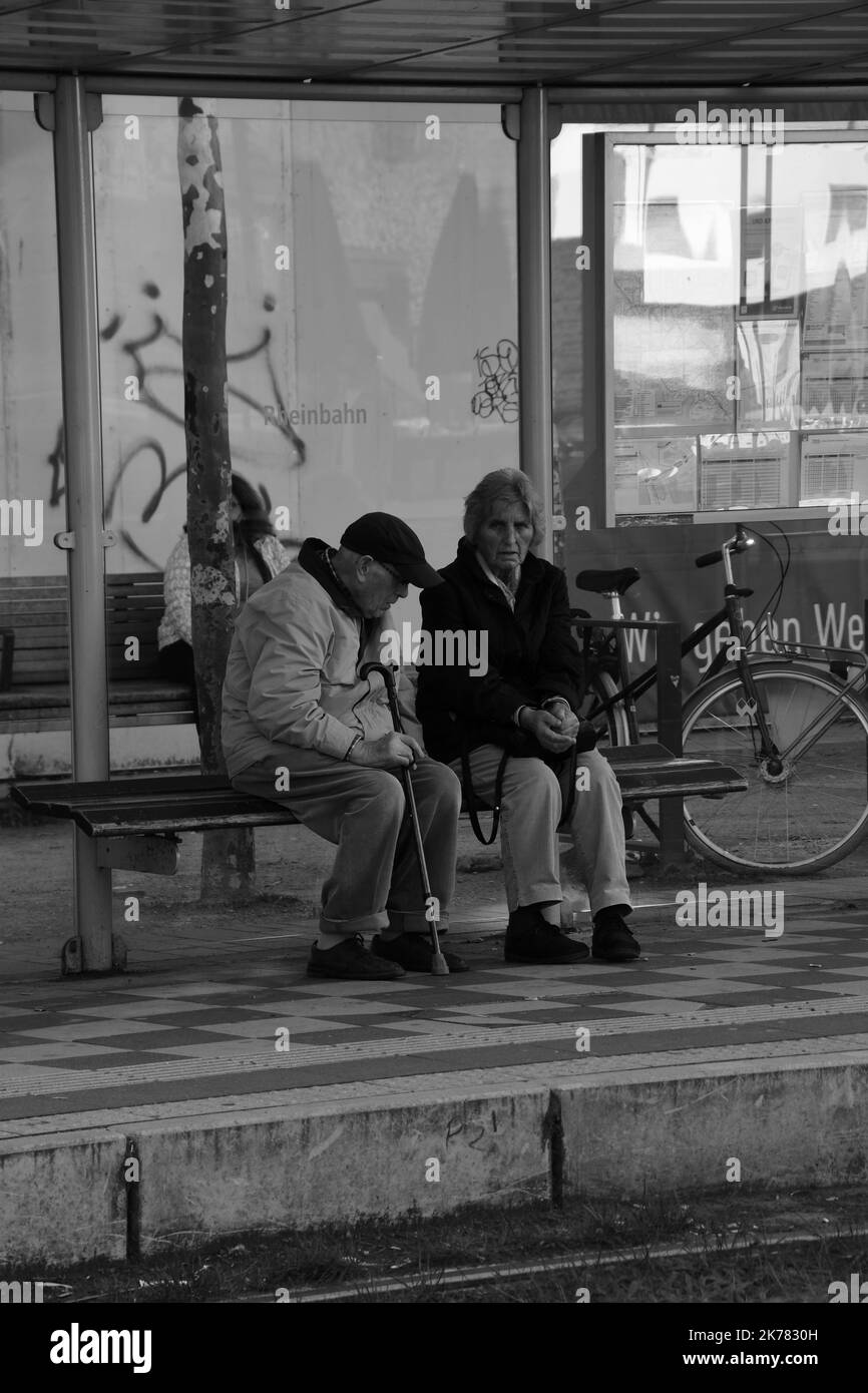 An elder pensioner couple waiting at bus stop in Dusseldorf, Germany Stock Photo