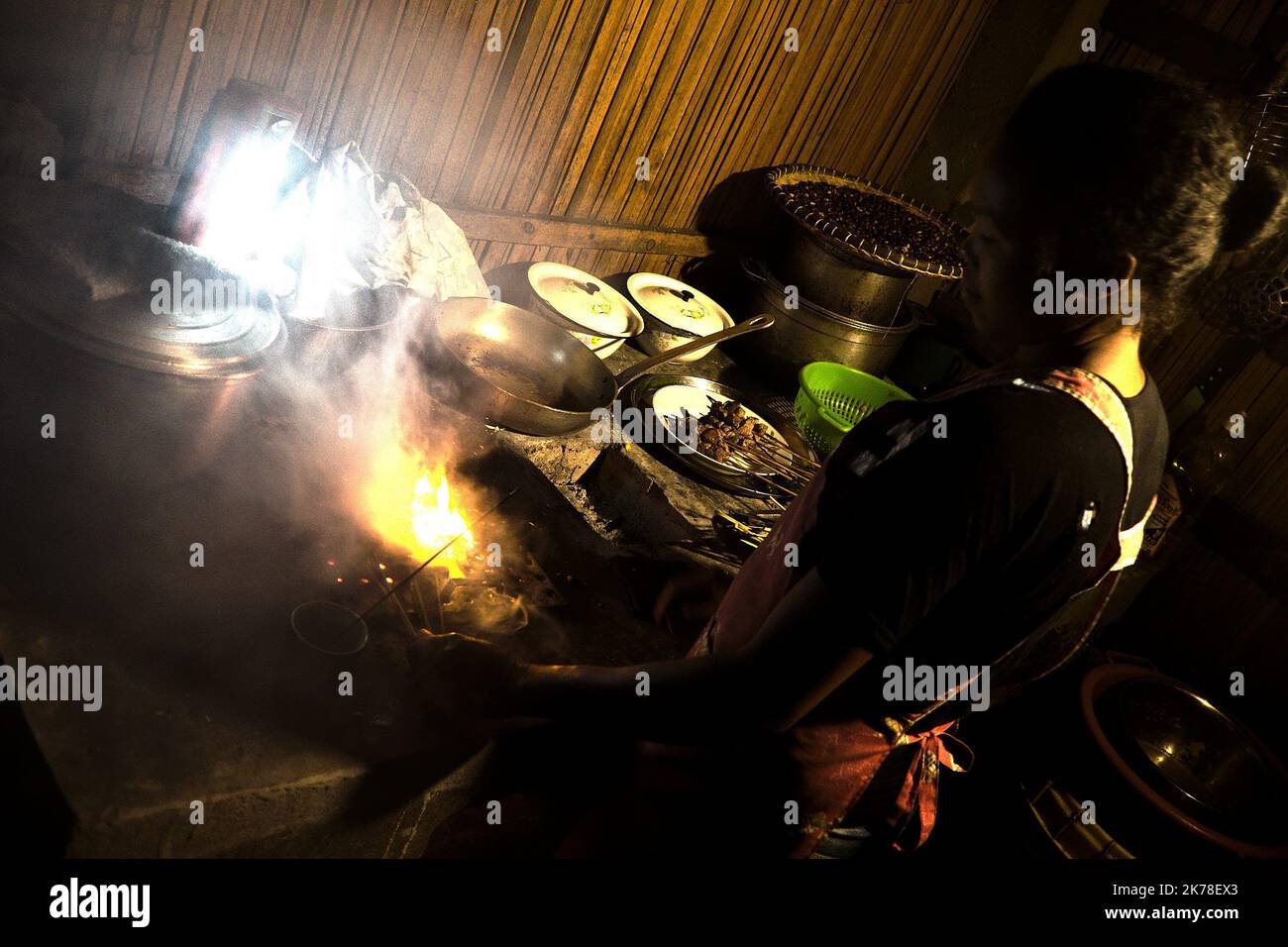 ©Arnaud De Grave / Le Pictorium/MAXPPP - Arnaud De Grave / Le Pictorium - 07/11/2015  -  Madagascar / Alaotra-Mangoro  -  Cuisiniere dans la fumee...  / 07/11/2015  -  Madagascar / Alaotra-Mangoro  -  Cook in the smoke... Stock Photo