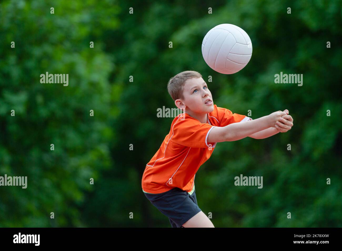School kid playing volleyball in a physical education lesson