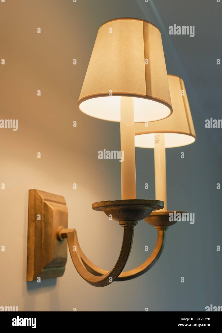 A classic looking double lamp wall fixture with lamp shades photographed in orange and teal color accent Stock Photo
