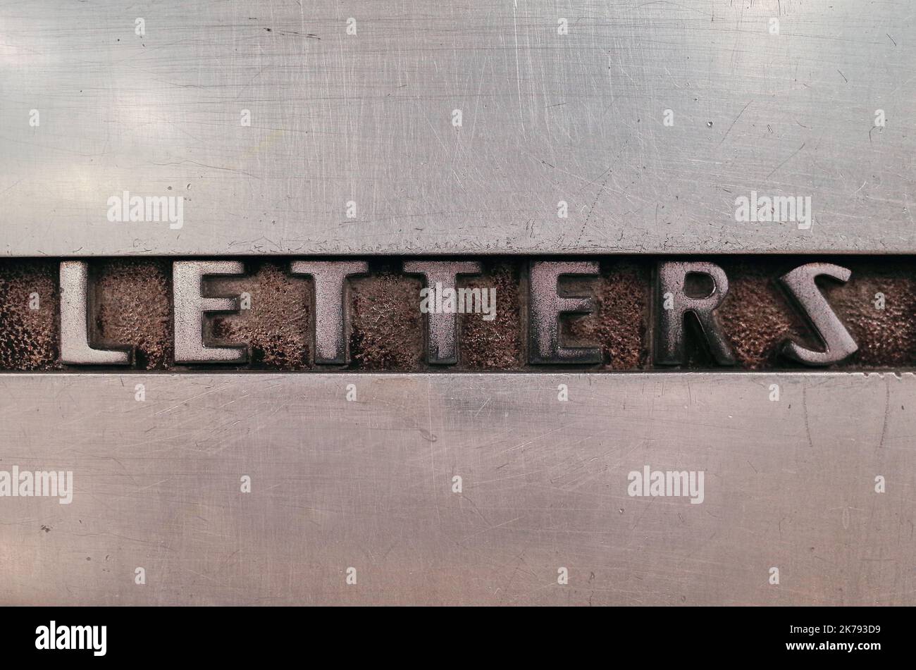 Word "letters" is cast etched into a steel surface of an old mail box