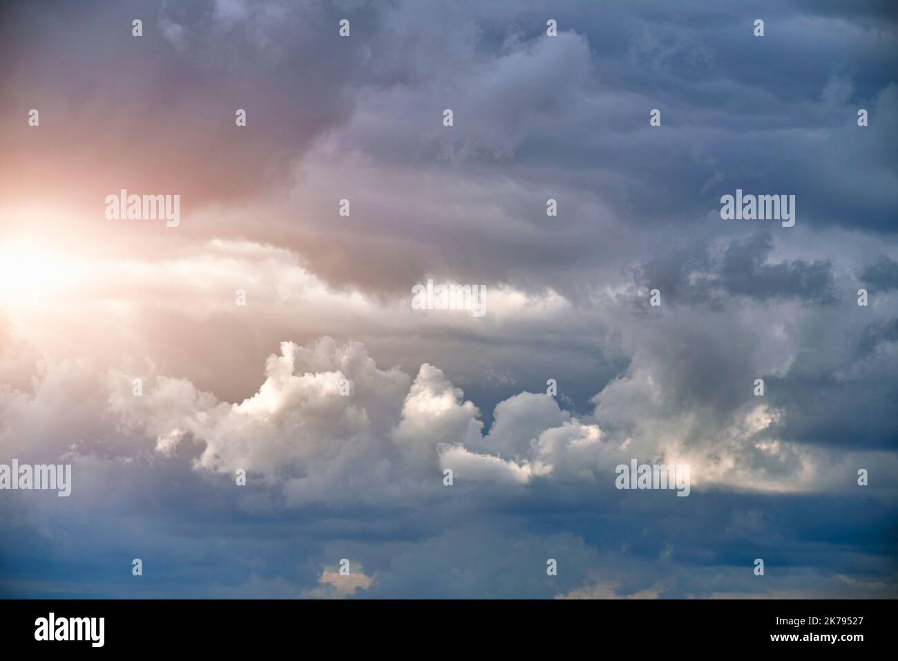 Breaking sunlight through gap of storm clouds Stock Photo