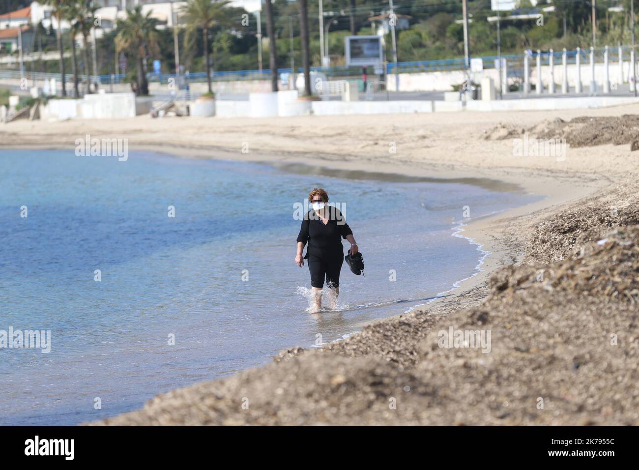 A woman walks along the French Riviera beach despite a ban on access to the beaches of Golfe-Juan Vallauris being introduced due to the Coronavirus epidemic Stock Photo