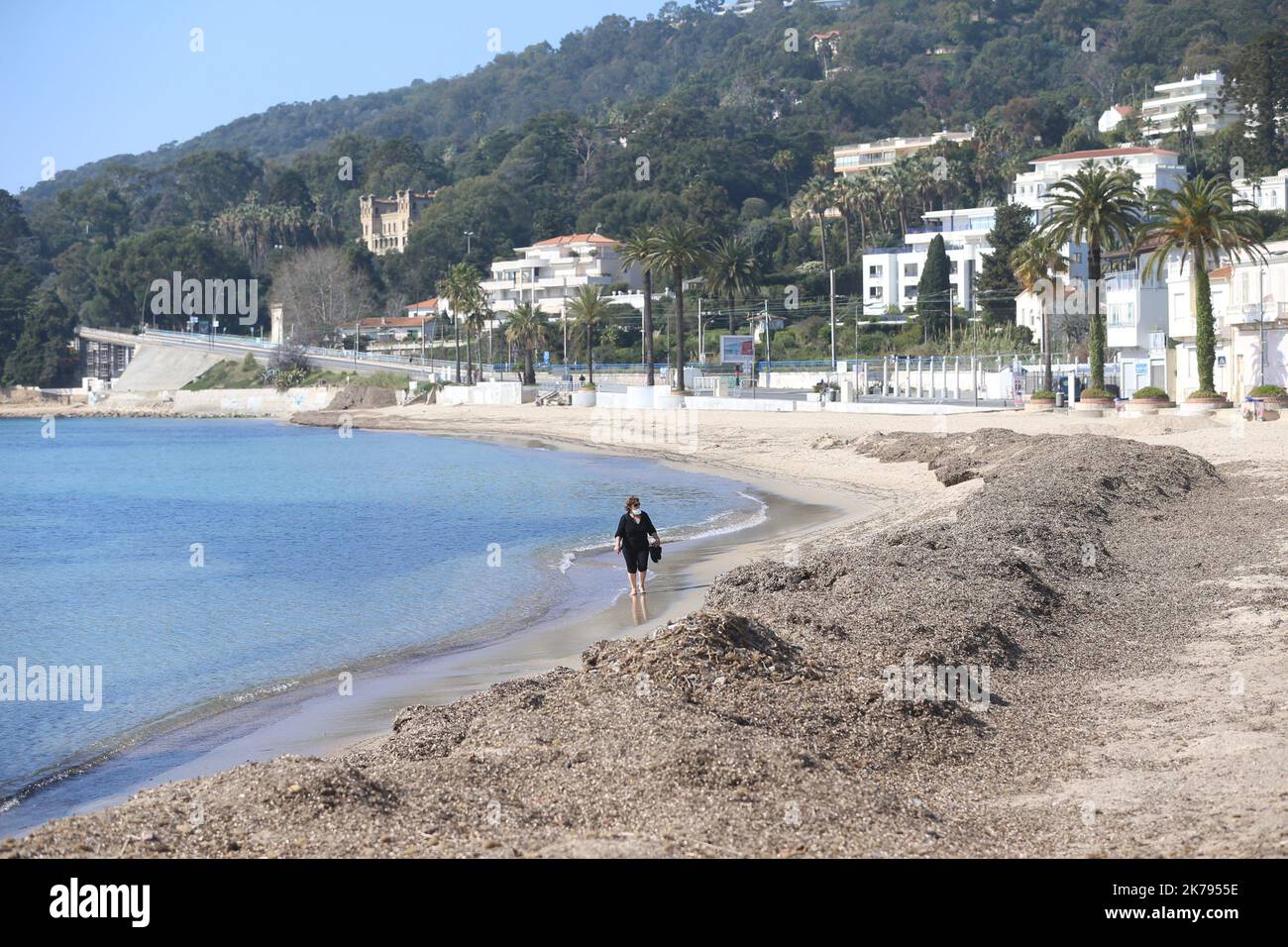 A woman walks along the French Riviera beach despite a ban on access to the beaches of Golfe-Juan Vallauris being introduced due to the Coronavirus epidemic Stock Photo