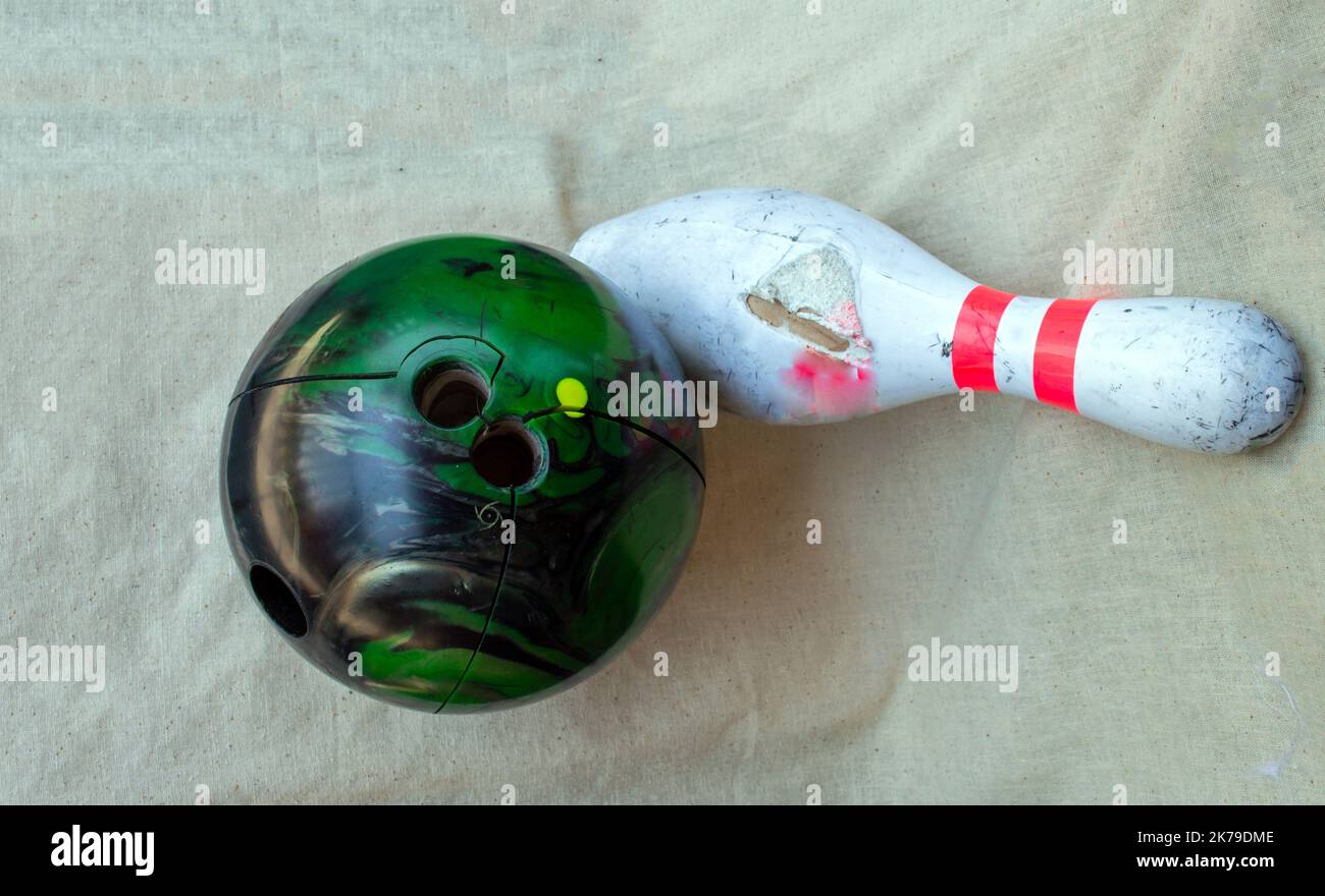 Time to purchase new bowling equipment. Both the bowling ball and bowling pin are beyond being used. Stock Photo