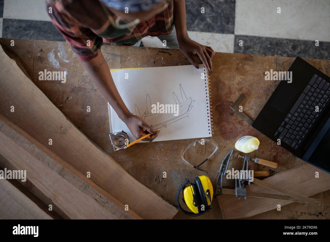 Overhead view of woman designing furniture on work bench Stock Photo