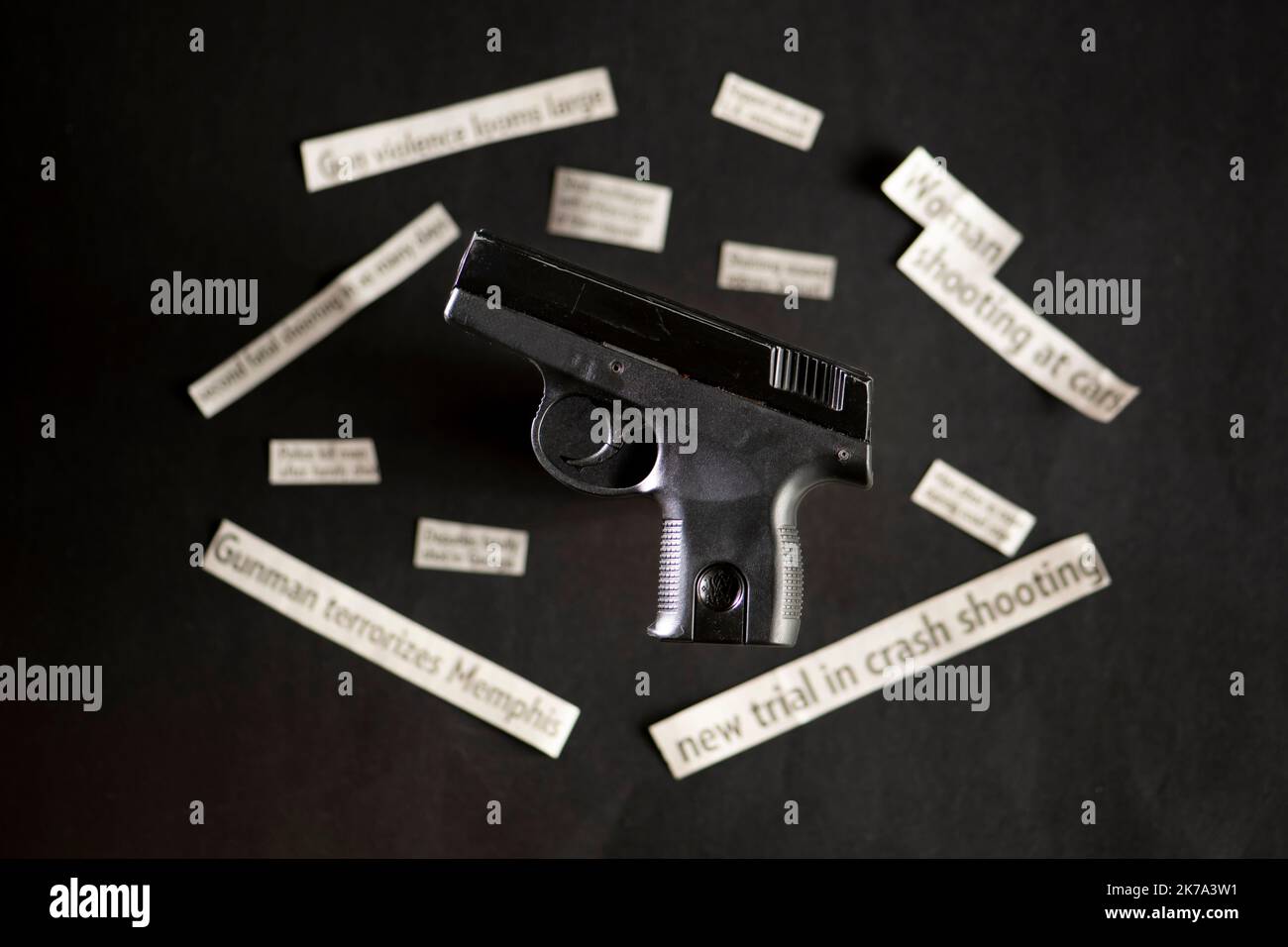 Handgun with out of focus gun violence newspaper headlines Stock Photo