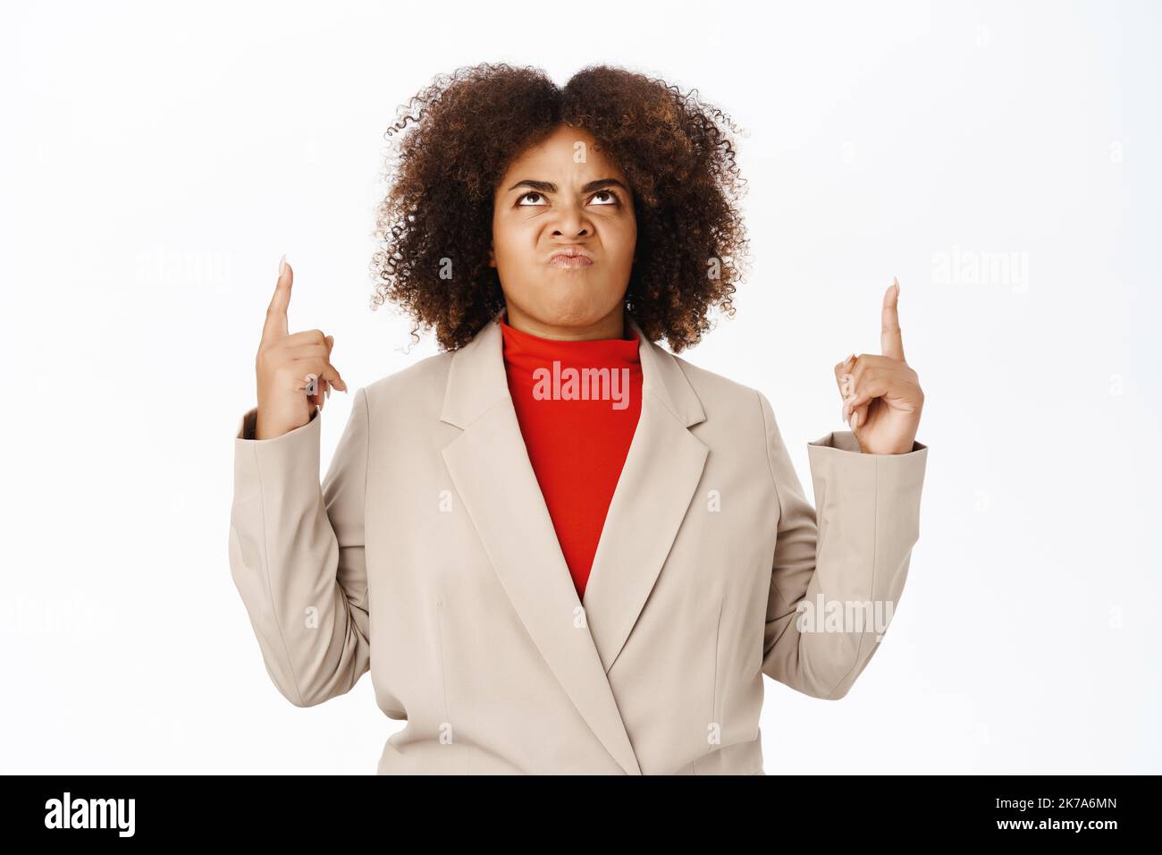 Disappointed, angry black saleswoman, pointing and looking up with