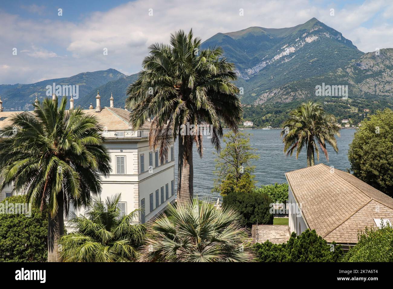 Villa Menzi with Palm Tree in Bellagio. Beautiful View of Italian Architecture with Lake Como and Hilly Mountain in Botanical Garden during Summer Day Stock Photo