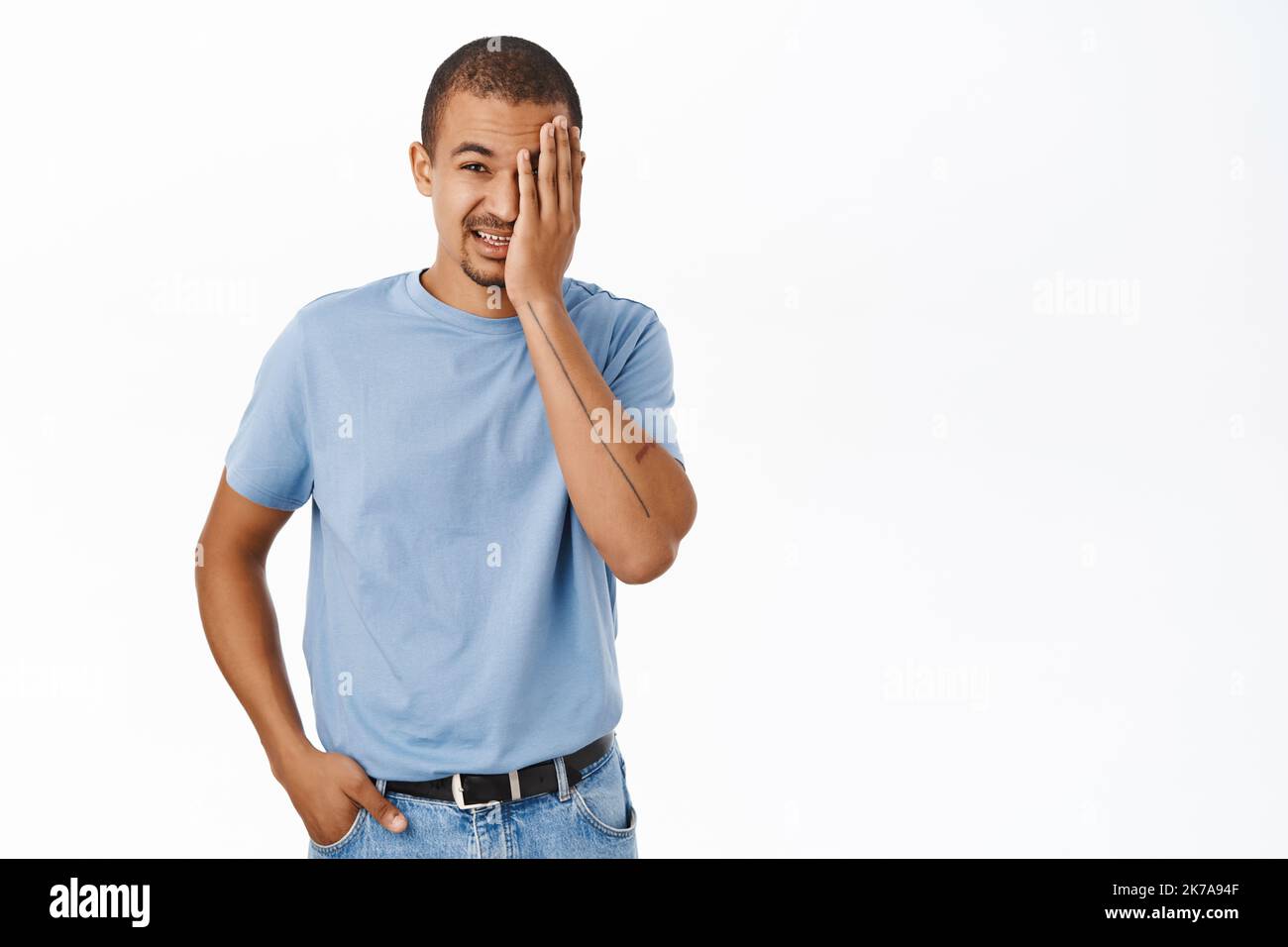 Image of guy facepalm, looking with pity and cringe at smth, disappointed, standing over white background Stock Photo