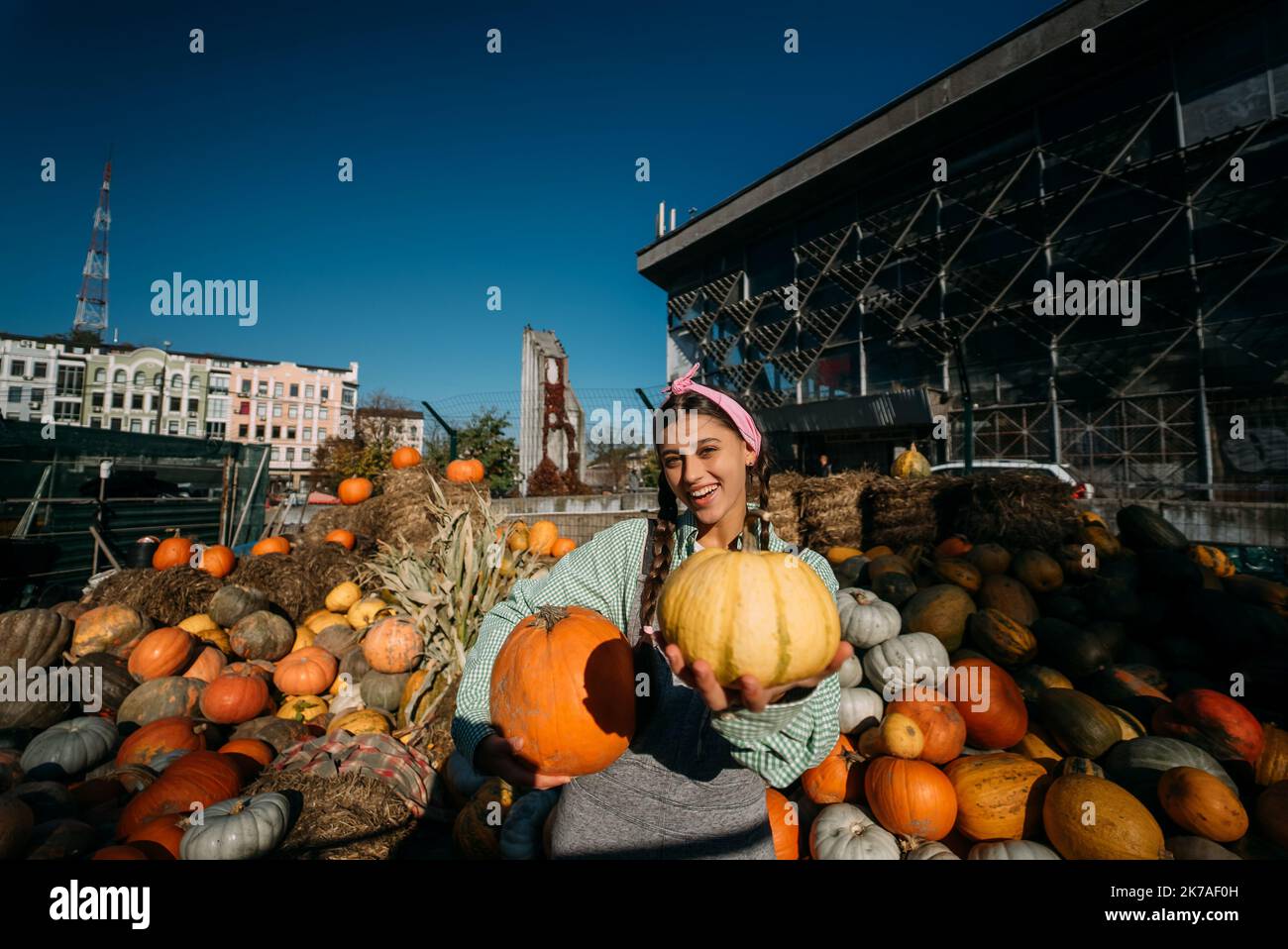 A young female seller is showing the autumn harvest Stock Photo