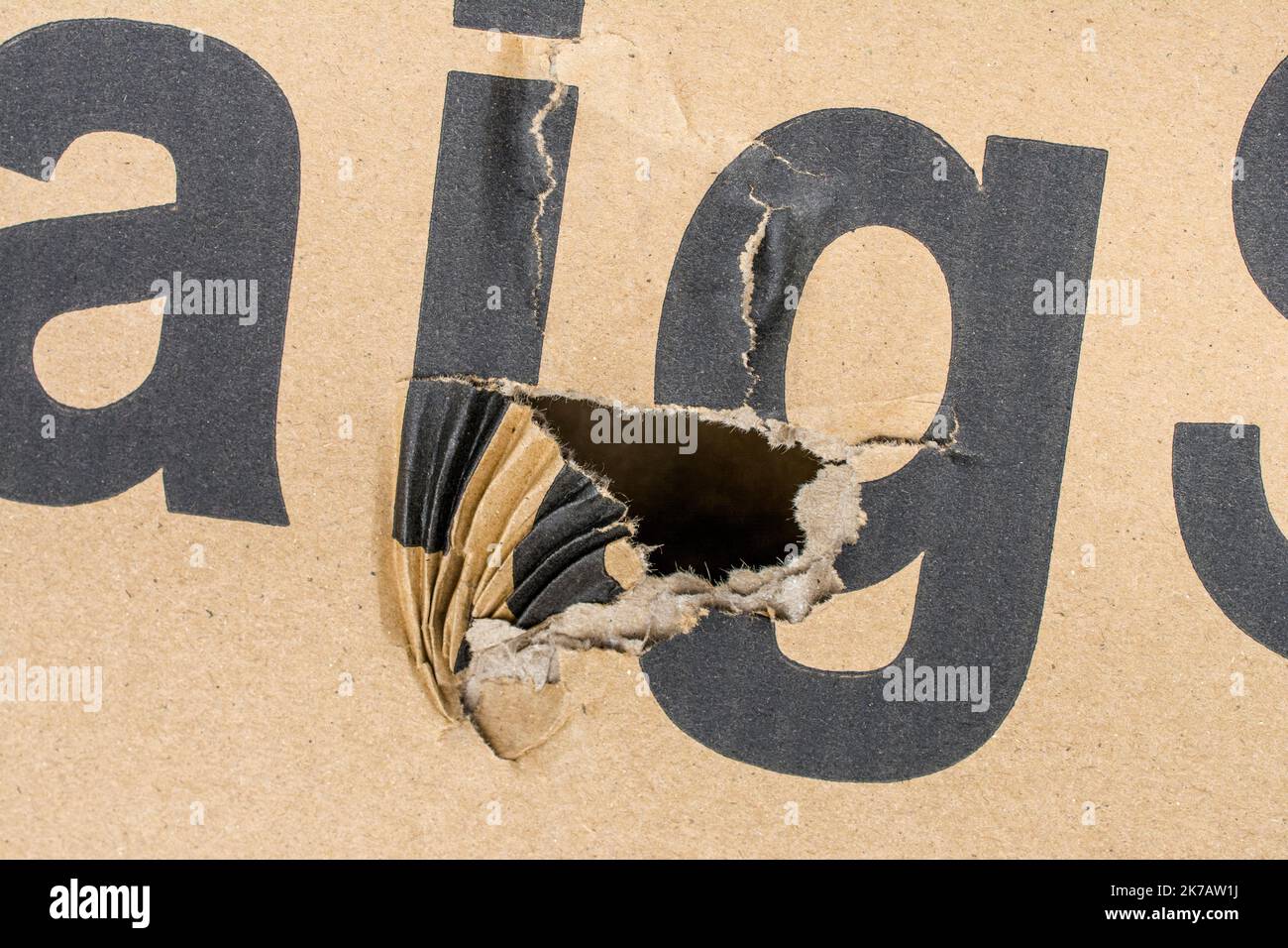 Visible signs of damage to a cardboard shipping box damaged in transit. Possibly for insurance claims, damage insurance, careless handling. Stock Photo