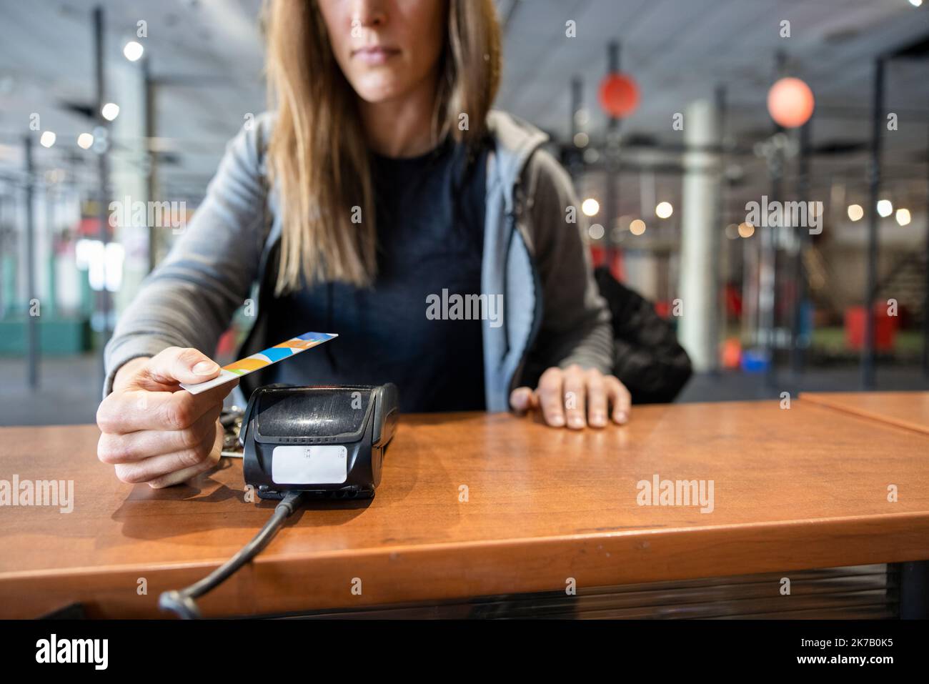 Close up woman paying for gym membership with smart card Stock Photo