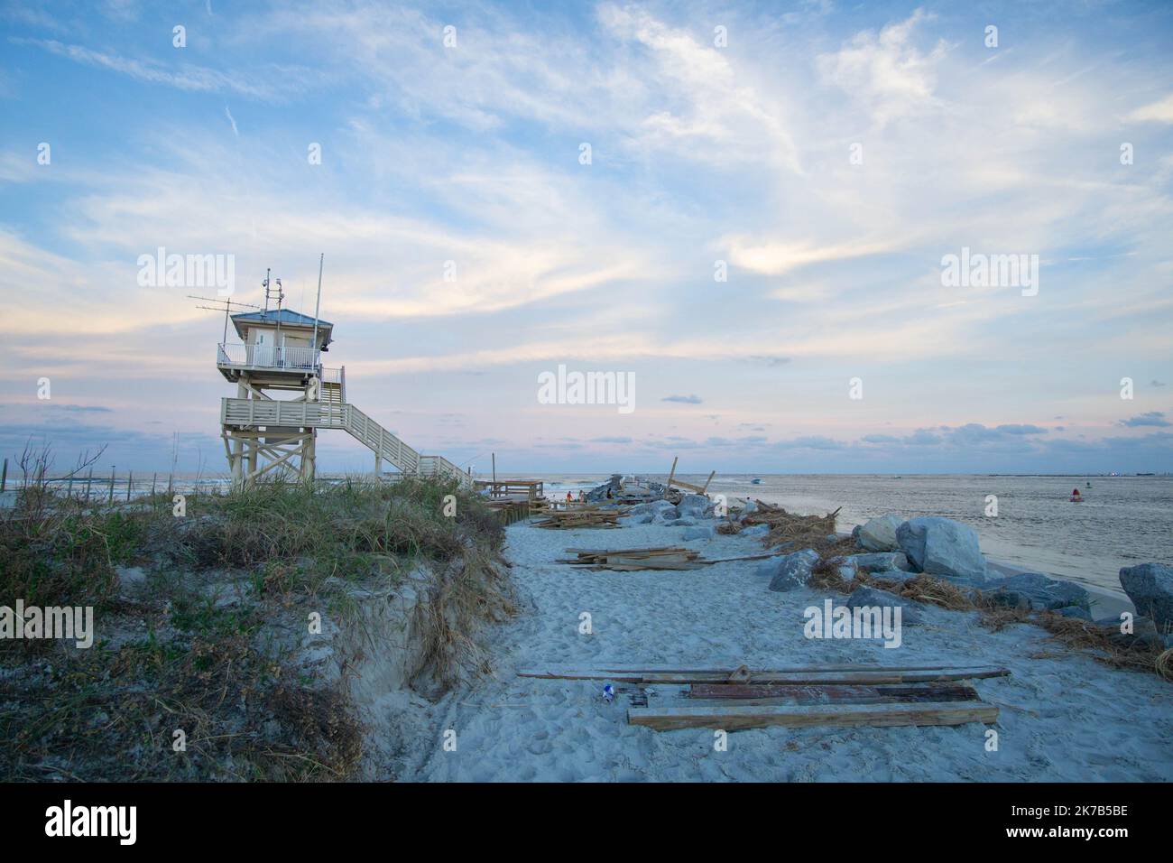 Wood from the Ponce Inlet jetty's destroyed boardwalk lie next to the lifeguard tower after Hurricane Ian. Stock Photo