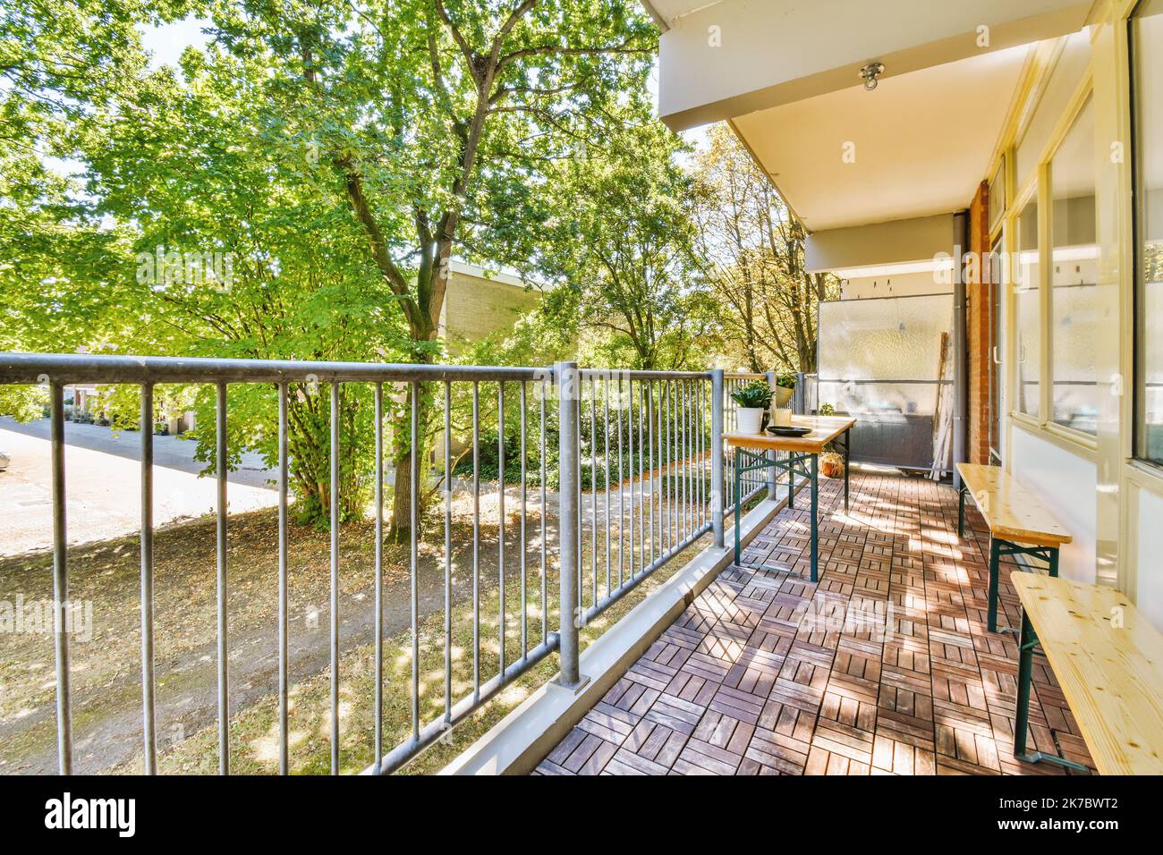 Narrow light corridor with doors of rooms illuminated with lamps inside