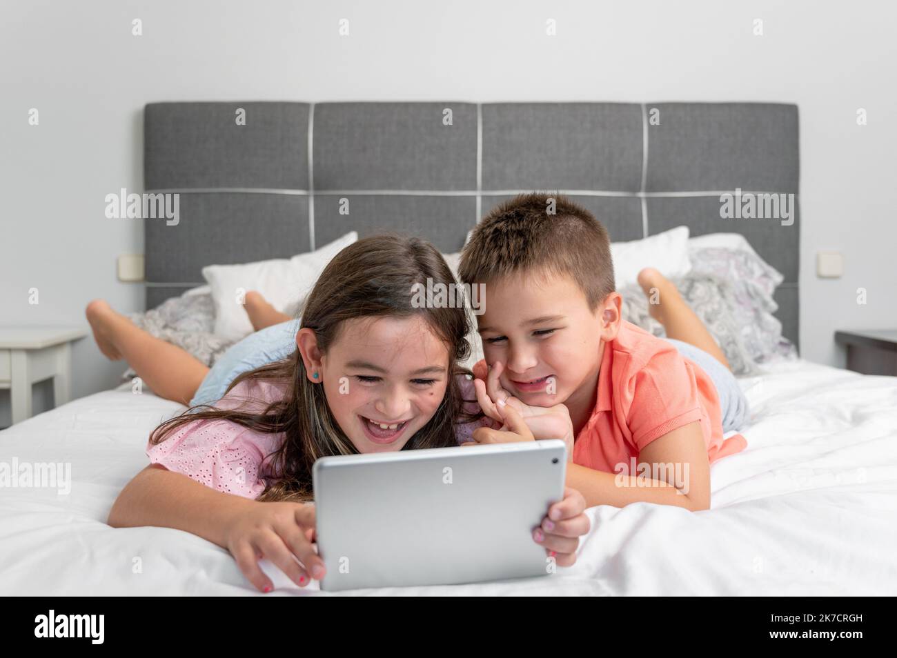 Cute little children with digital tablet using internet at home. Caucasian little sister and brother siblings surfing Internet, watching animated cartoons online on the bed. High quality photography Stock Photo - Alamy Cute little children with digital tablet using internet at home. Caucasian little sister and brother siblings surfing Internet, watching animated cartoons online on the bed. High quality photography Stock Photo - Alamy
