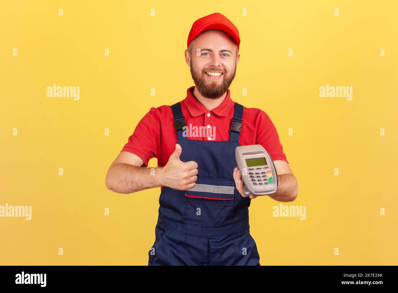 Smiling positive worker man holding in hand pos contactless payment ...
