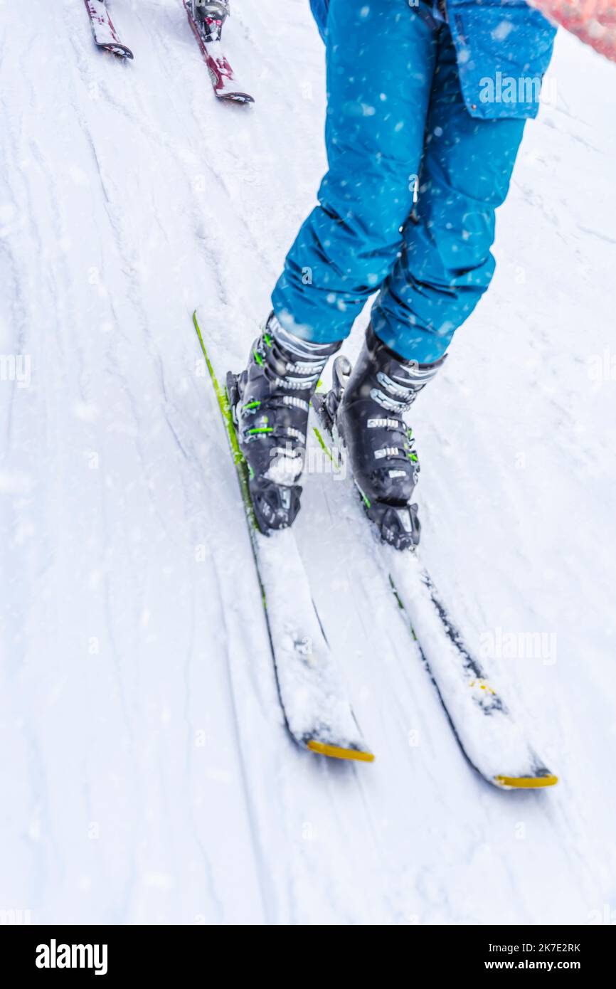 Legs of skier in blue sports trousers and ski on ski slope . Concept of winter sport Stock Photo