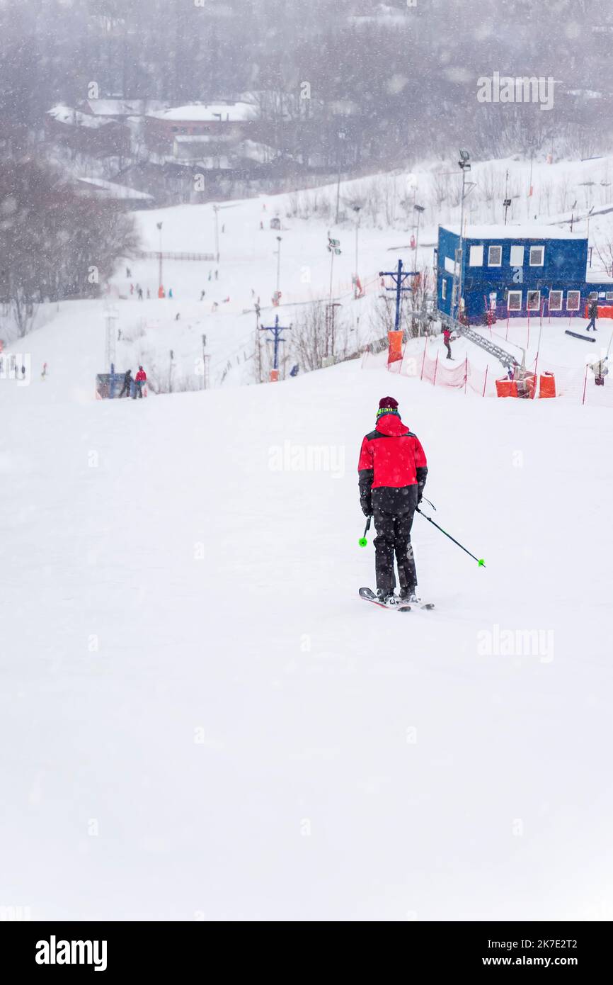 View down slope, skiing, skier back view. Winter sport Stock Photo