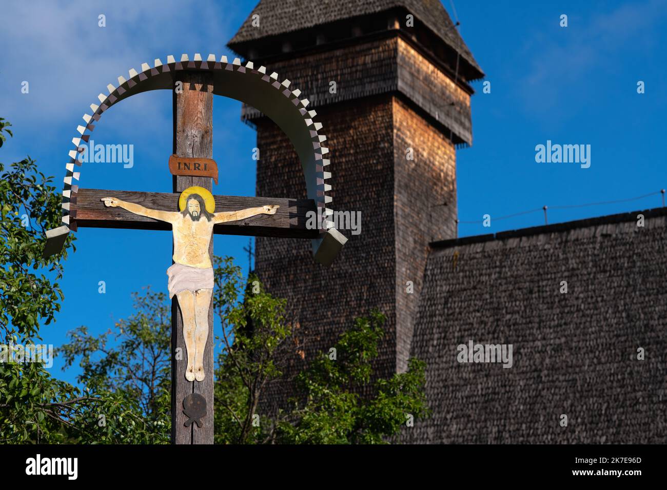 Old cemetery traditional cross depicting Jesus with a wood church in ...