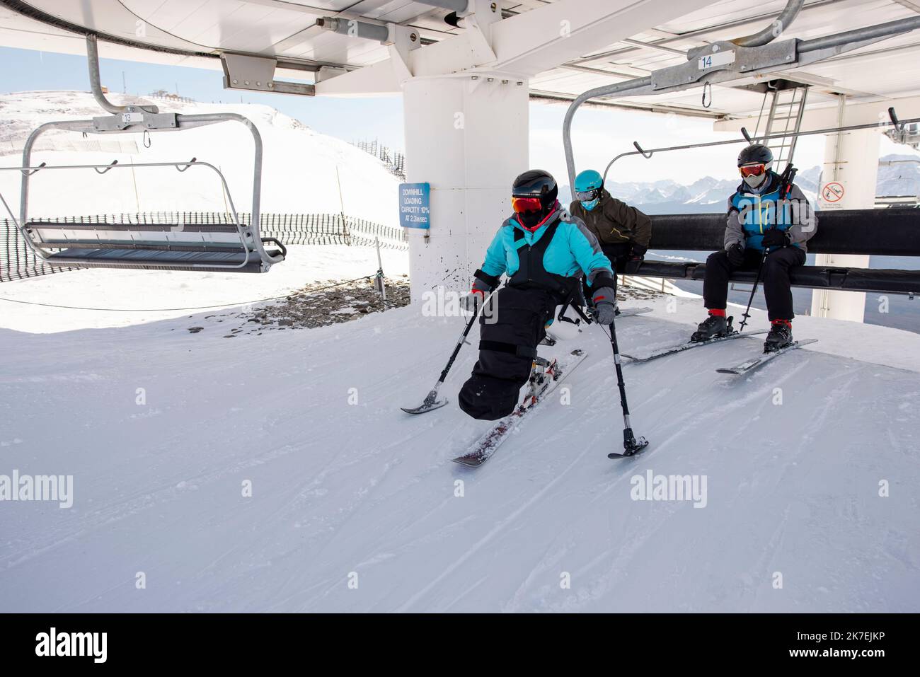 Para alpine skier getting off chair lift at ski resort Stock Photo Alamy