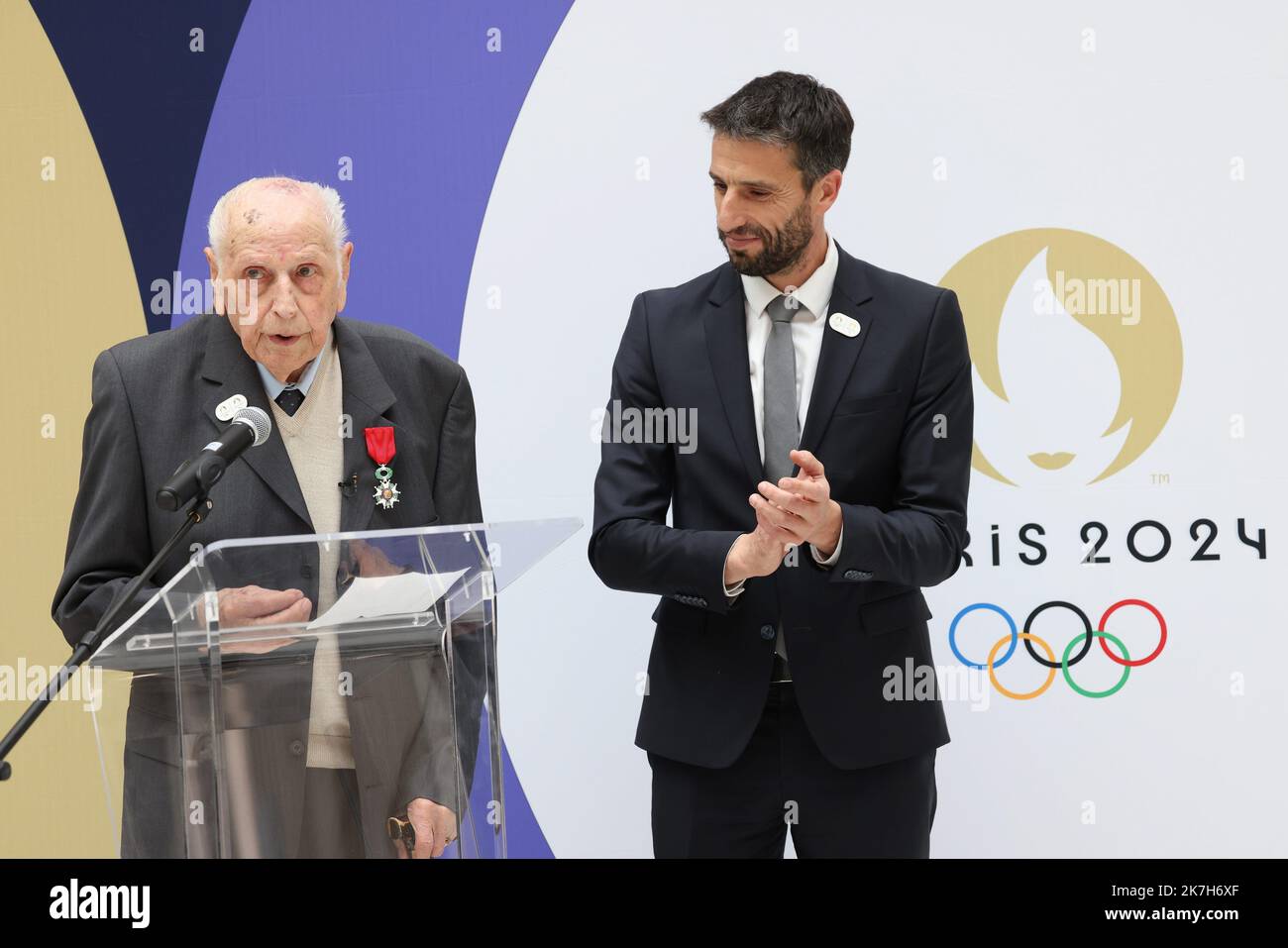 ©PHOTOPQR/LE PARISIEN/Olivier Lejeune ; saint denis ; 13/04/2022 ; Cérémonie de Remise de la Légion d’honneur à Charles Coste au siège de Paris 2024 Le 13 avril prochain, Paris 2024 organise la cérémonie de Remise des insignes de la Légion d’honneur à Charles Coste. Né en 1924 et âgé de 98 ans, il est le plus ancien Champion Olympique français. En présence Tony Estanguet, Président du comité d’organisation des prochains Jeux d’Eté en France. French President of the Paris Organising Committee of the 2024 Olympic and Paralympic Games Tony Estanguet (R) greets French cyclist Charles Coste (C), O Stock Photo