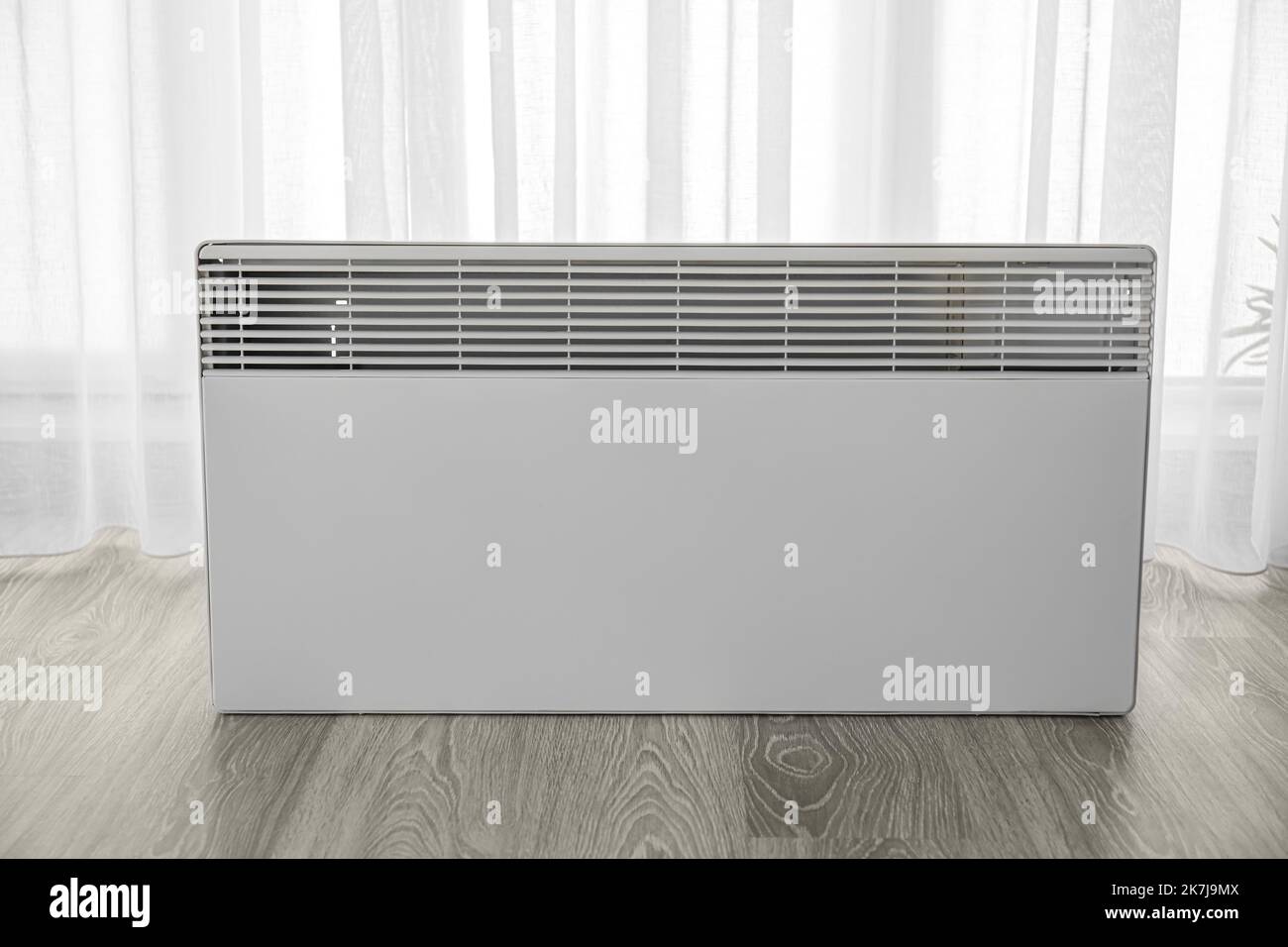 Radiator near light curtain in room. Heating season concept Stock Photo