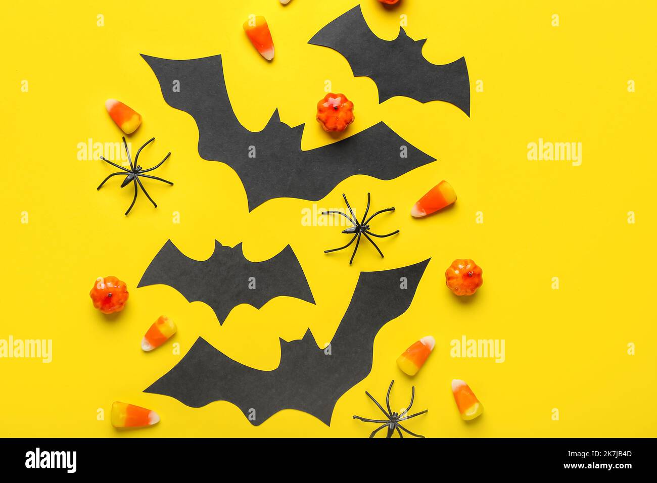 Paper bats with Halloween treats and spiders on yellow background Stock ...