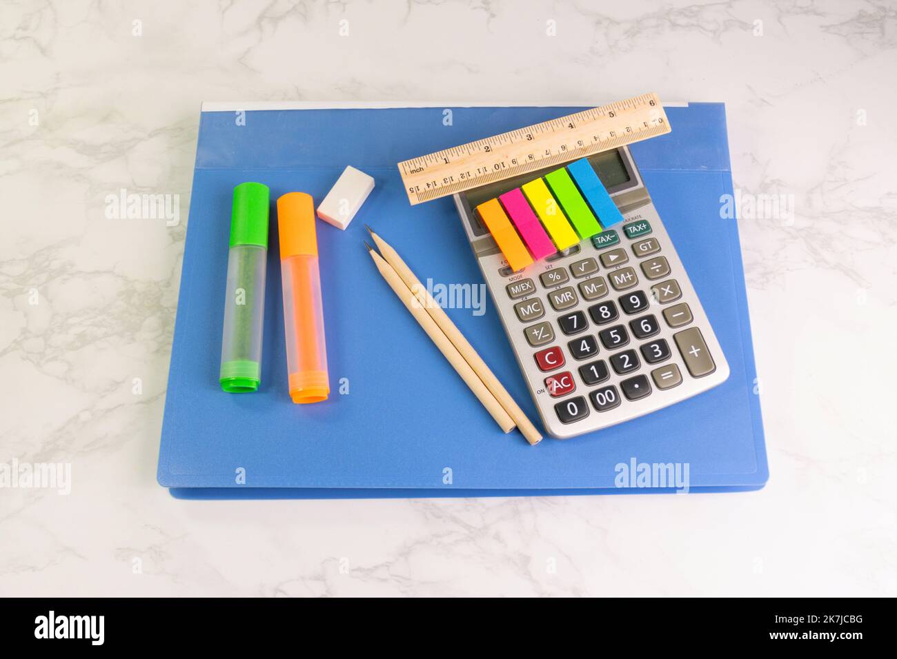 blue folder and writing equipment with Calculator, highlighter, pencil, ruler, eraser on the white table at the office Stock Photo