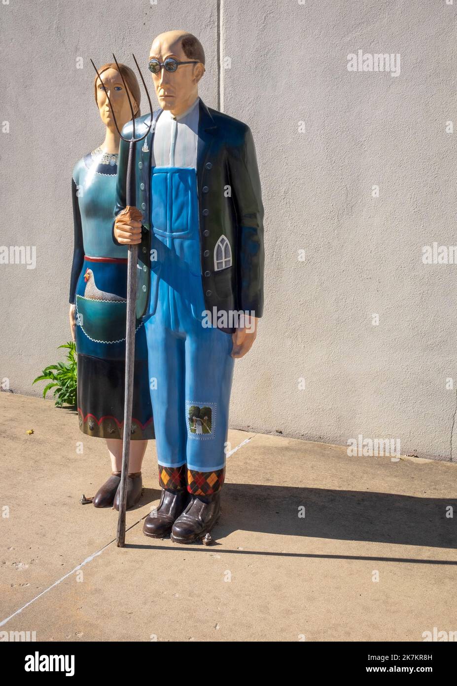 Grant Wood's American Gothic House, Eldon, Iowa; statues of man and woman with a pitchfork Stock Photo