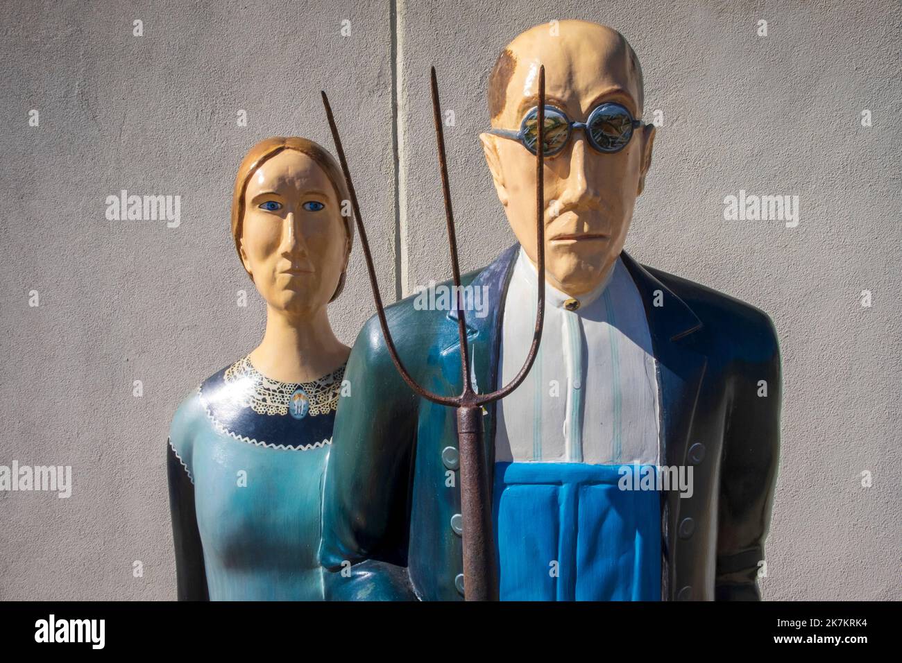 Grant Wood's American Gothic House, Eldon, Iowa; statues of man and woman with a pitchfork Stock Photo