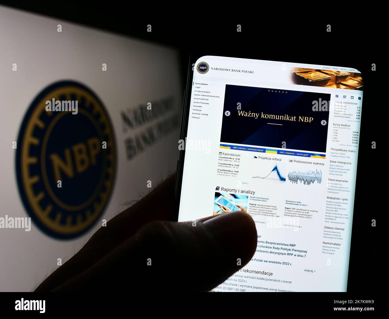 Person holding cellphone with webpage of Polish central bank Narodowy Bank Polski (NBP) on screen with logo. Focus on center of phone display. Stock Photo