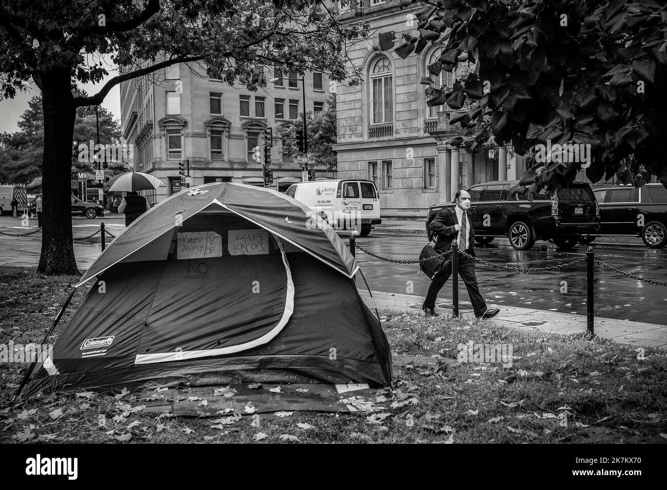 A man passes by tents where people who are homeless live in McPherson Square in Washington, DC, Thursday, October 13, 2022. In this federal park, where the homeless and general public seem to coexist, there are about three dozen tents in the park, with laundry hanging on tree branches, chairs, tables and even two portable bathrooms. Credit: Rod Lamkey/CNP (RESTRICTION: NO New York or New Jersey Newspapers or newspapers within a 75 mile radius of New York City) Stock Photo