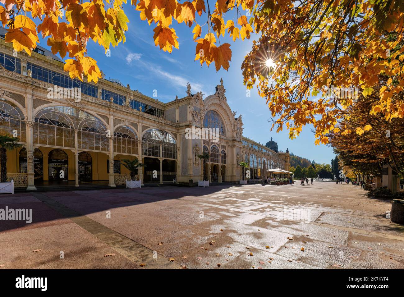 Autumn atmosphere in Czech spa Marianske Lazne (Marienbad) - building of main colonnade - sunny autumn day with blue sky and yellow tree leaves - Stock Image