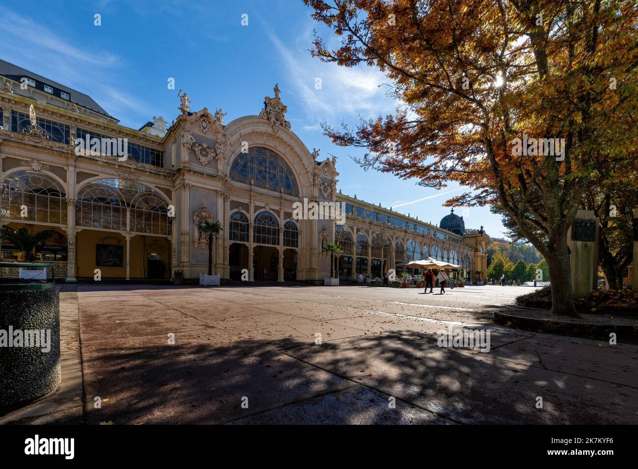 Autumn atmosphere in Czech spa Marianske Lazne (Marienbad) - building of main colonnade - sunny autumn day with blue sky and yellow tree leaves - Stock Image