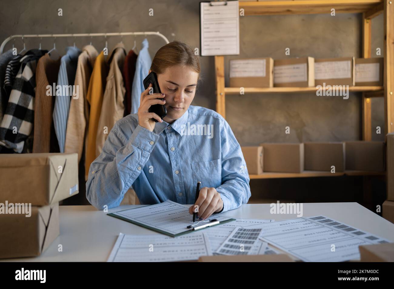 SME business women use mobile phone checking customer order online shipping boxes at home. Starting Small business entrepreneur SME freelance. online Stock Photo