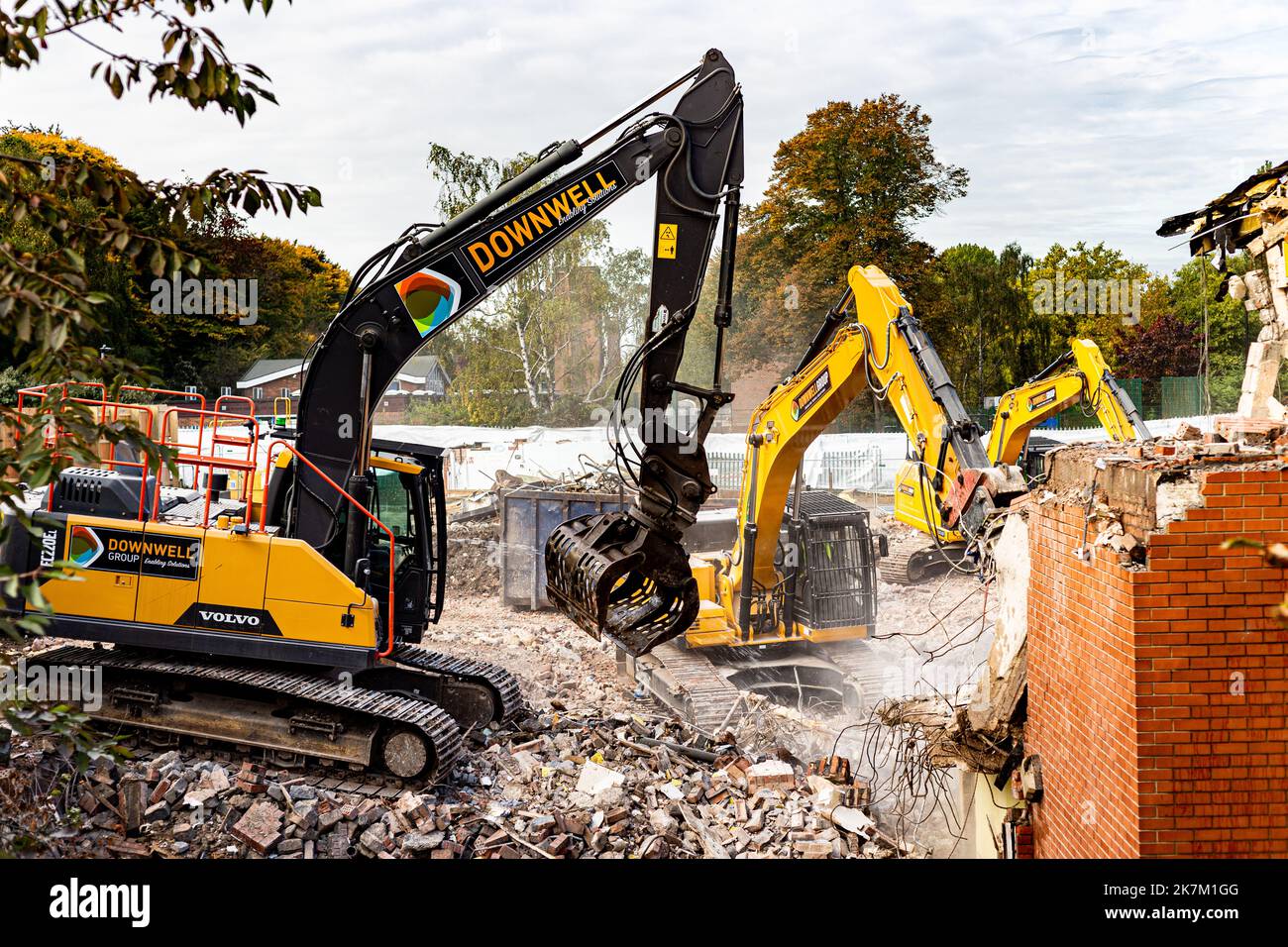 Three demolition Excavators working at a site in North London clearing the way for a large new housing scheme.Action shot removing bricks and rubble. Stock Photo
