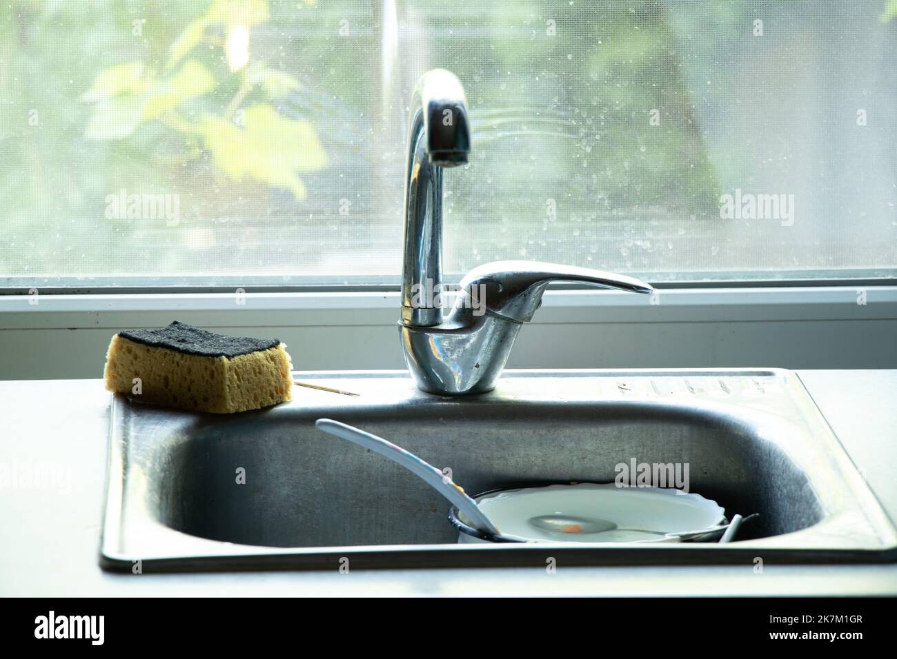 dirty dishes in the sink on the table in the kitchen under the tap