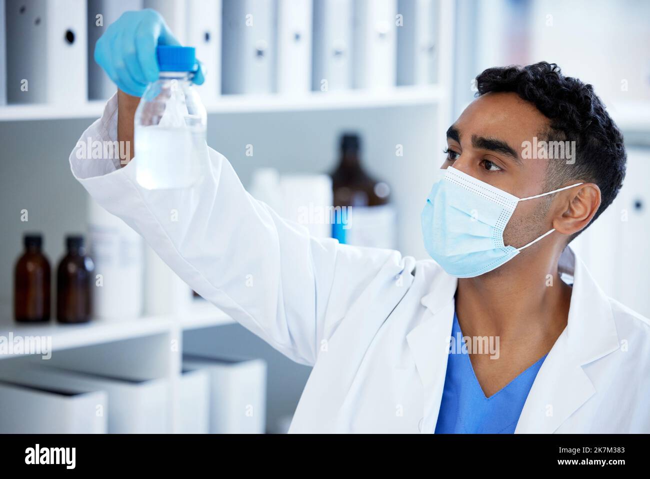 I hope this works. a young man analysing a sample in a lab. Stock Photo