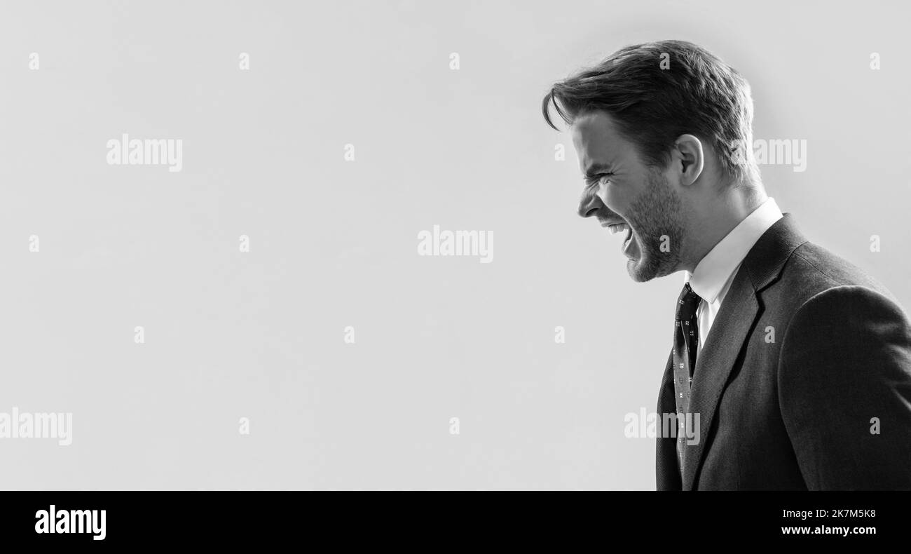 Businessman sideway shout angry grey background copy space, anger Stock Photo