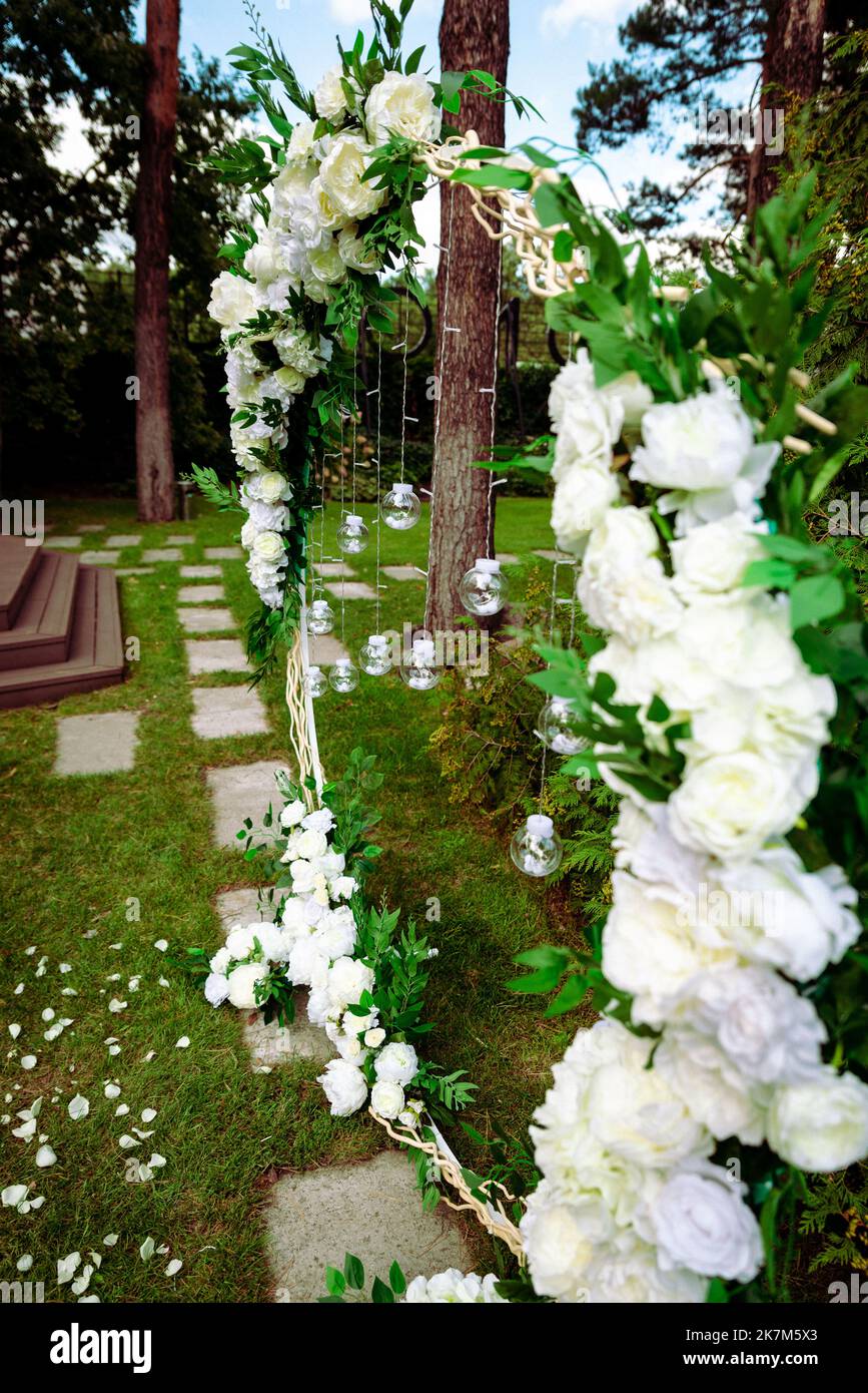 Wine glasses, wedding rings bedding of grass and moss on white table next  to bohemian tipi arch decorated in boho style with flowers and candles and  Stock Photo - Alamy