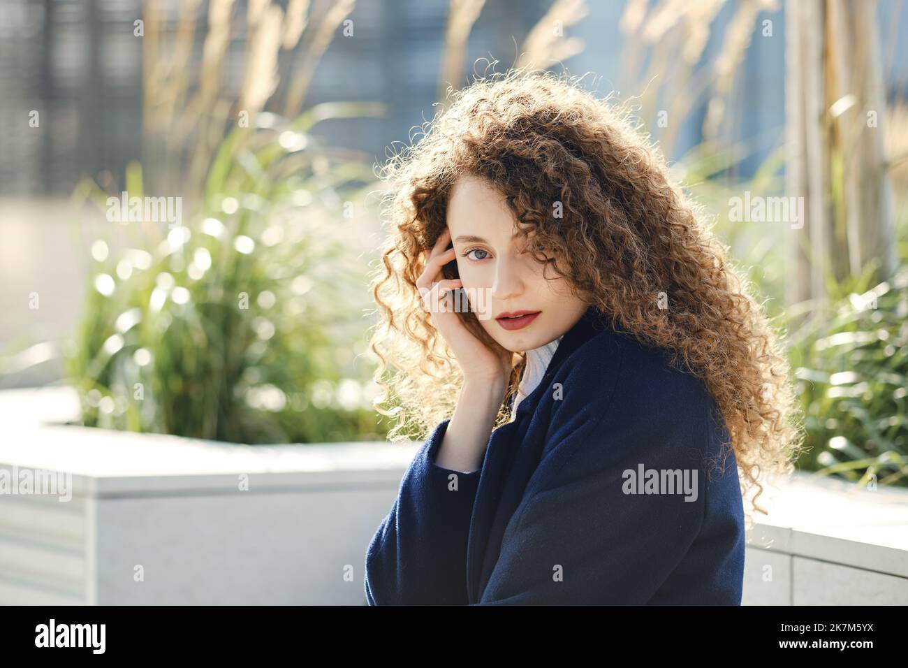 Portrait of a cute young woman with brown curly hair Stock Photo - Alamy