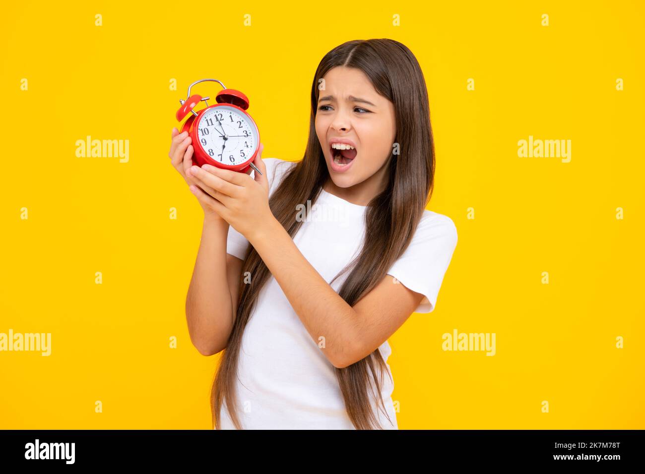 Teen student girl hold clock isolated on yellow background. Time to