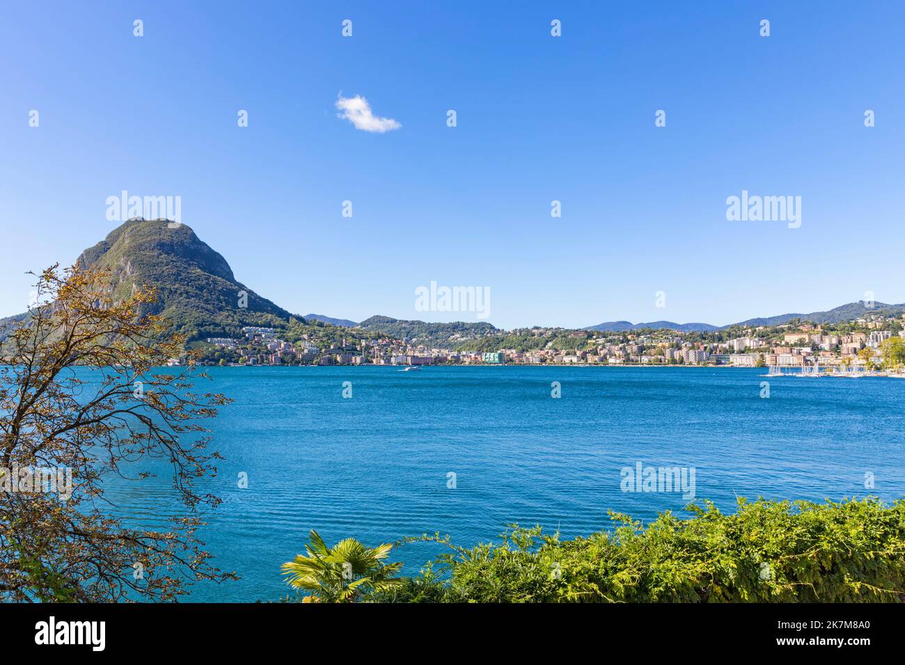 City of Lugano, Switzerland, with Monte San Salvatore, a ferry crossing the lake Stock Photo