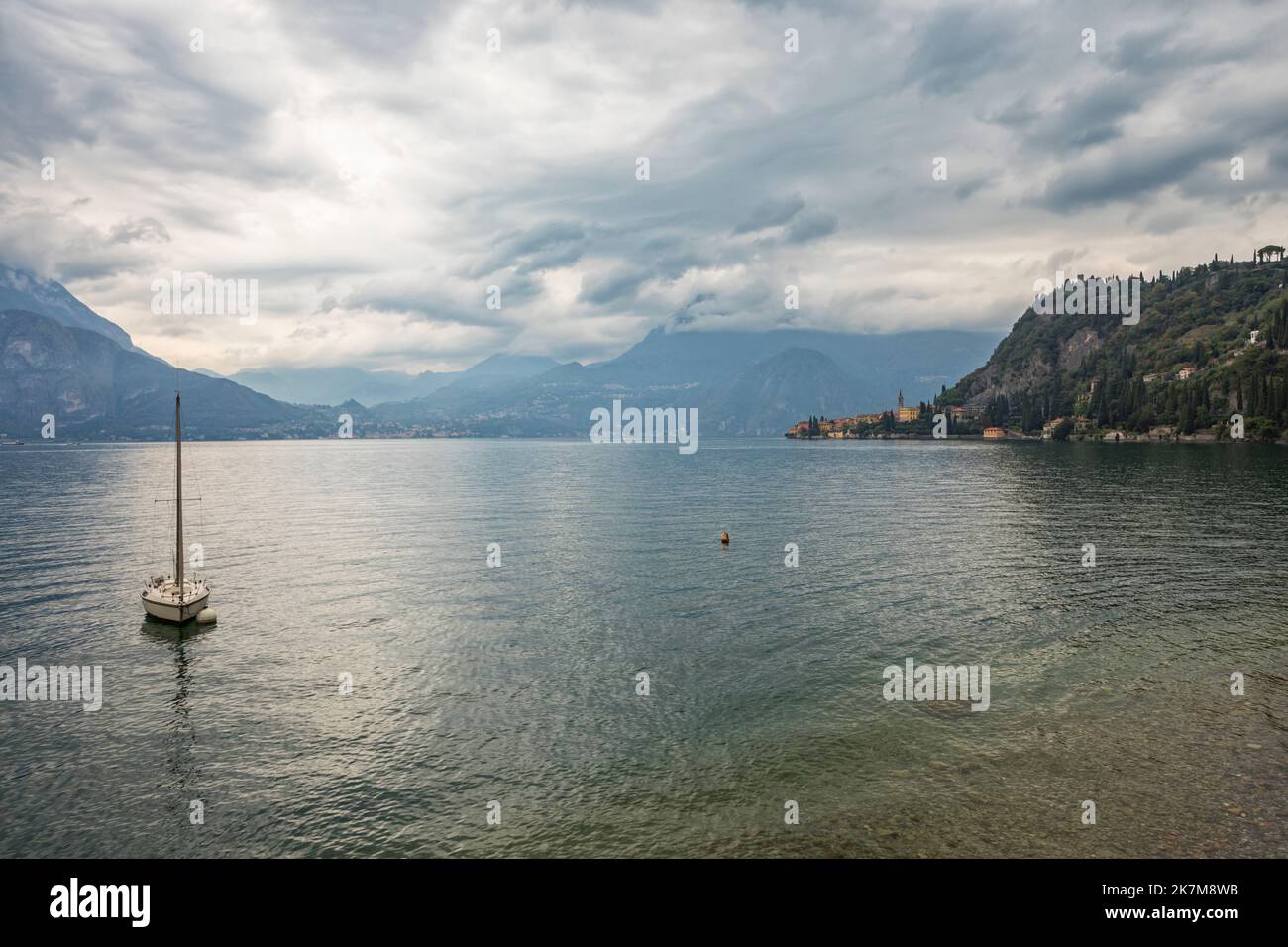 View of lake Como near Varenna viewing to Menaggio, moored sail boat in foreground Stock Photo