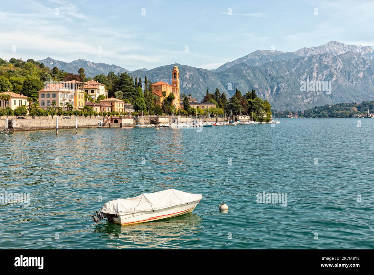 Tremezzo on western lakeside of Lake Como, Lombardy, Italy with church of San Lorenzo and marina. Moored boat in foreground. Stock Photo